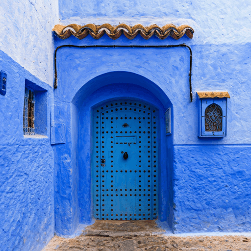 Ornate wooden door set into a bright blue painted wall in Chefchaouen